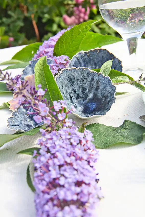 Décoration de table : fleurs en céramique parmi le lilas